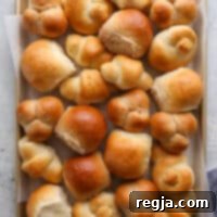 Ένα ταψί γεμάτο με ψωμάκια για το τραπέζι σε διάφορα σχήματα και γεύσεις.
