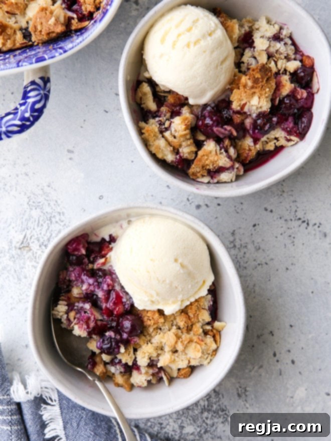 Τέλειο blueberry almond crisp, έτοιμο να σερβιριστεί, με ζουμερή γέμιση μύρτιλων και τραγανή επικάλυψη βρώμης και αμυγδάλων.