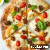Πίτσα με ιταλικό λουκάνικο, πιπεριές, ντομάτες και βασιλικό 9 Ένα χέρι παίρνει ένα κομμάτι ιταλικής πίτσας με λουκάνικο