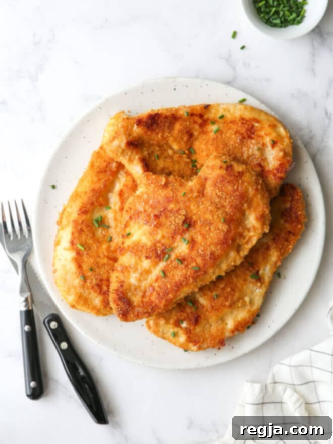 Κοτόπουλο φούρνου με κρούστα 2 oven fried chicken piled on a plate with chives