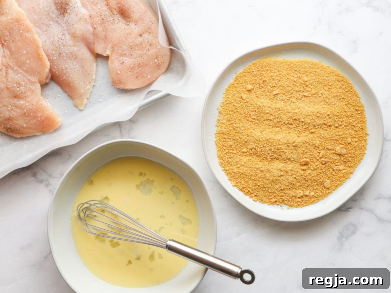 chicken ready with whisked egg and cornflake crumbs