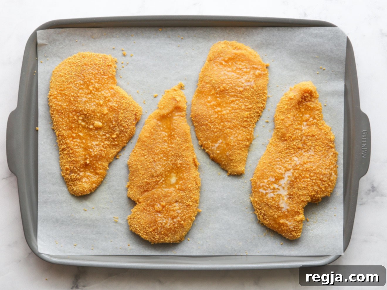 chicken ready for the oven on a sheet pan