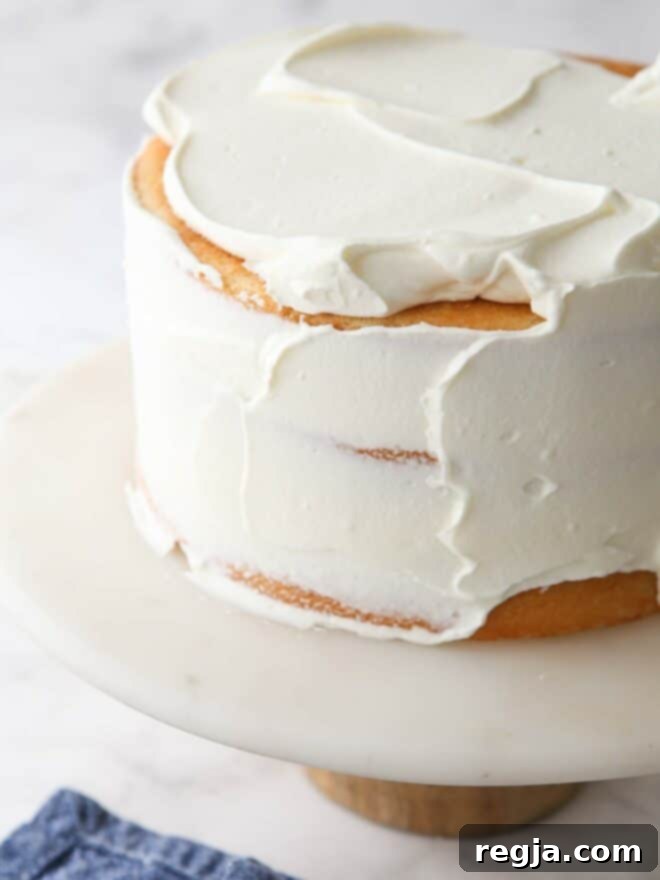 spreading chantilly cream frosting on a cake