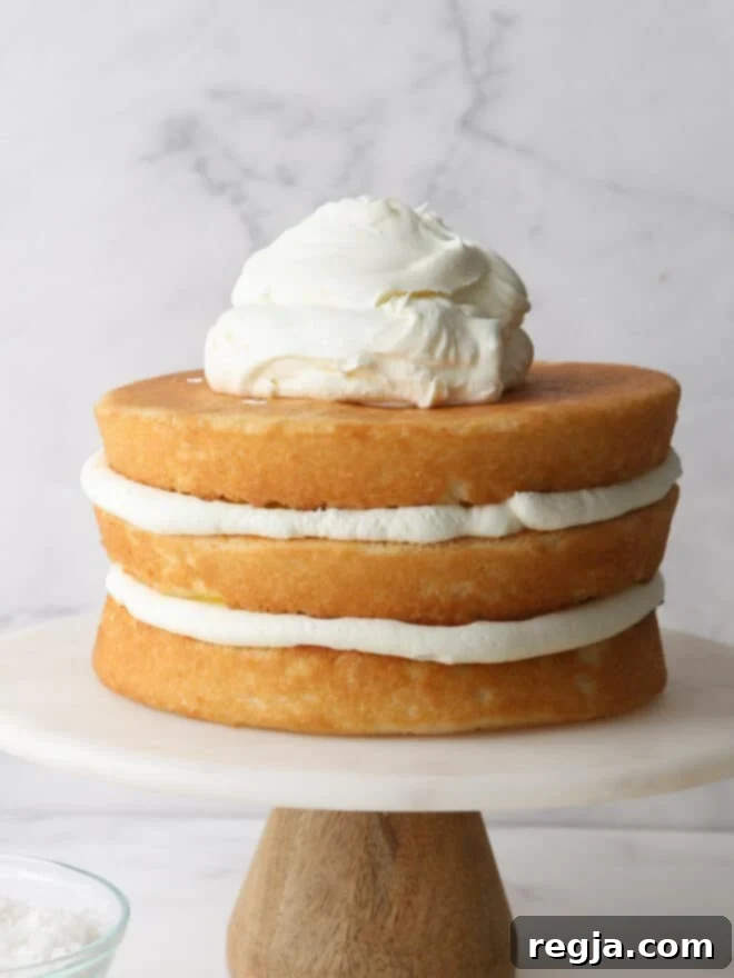piling chantilly cream frosting on a layer cake