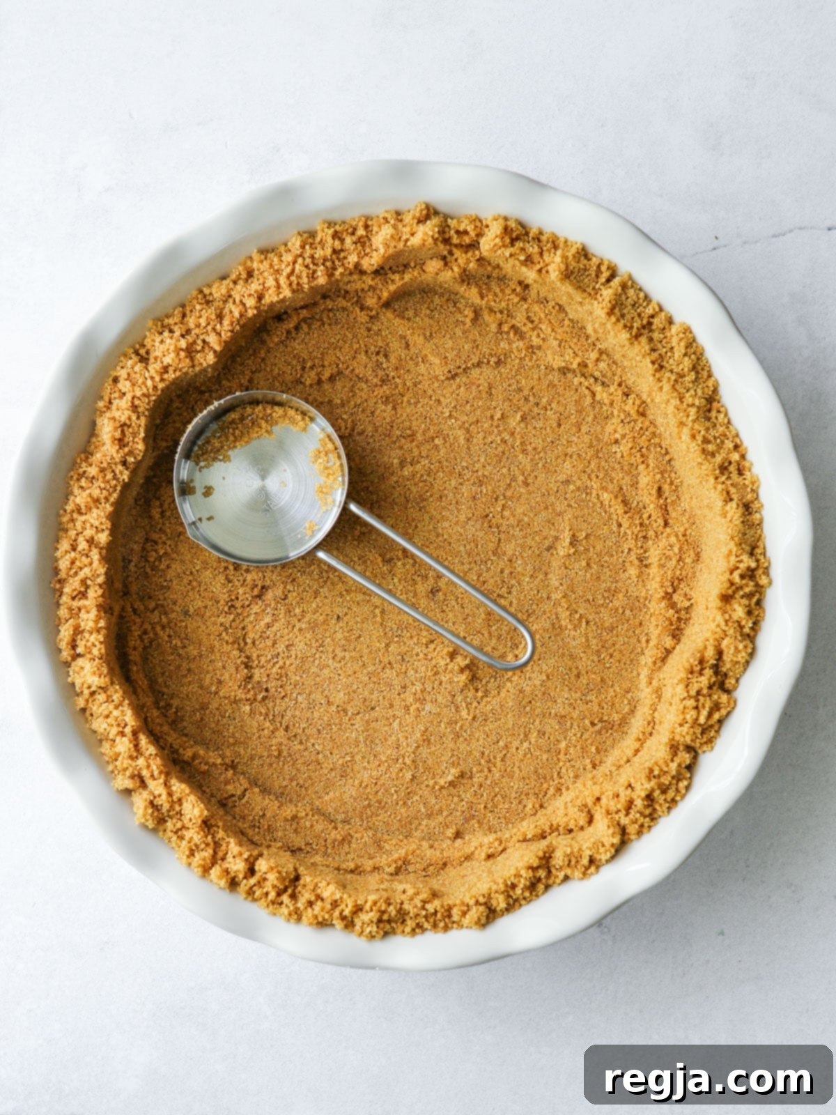 Πίεση της βάσης graham cracker σε ταψί τάρτας