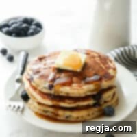 Στοίβα από αφράτες πανκέικ βουτυρόγαλου με μύρτιλα, βούτυρο και σιρόπι σφενδάμου