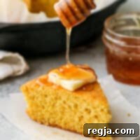 Ρίχνοντας μέλι σε μια φέτα κορνμπρέντ με μέλι και βουτυρόγαλα