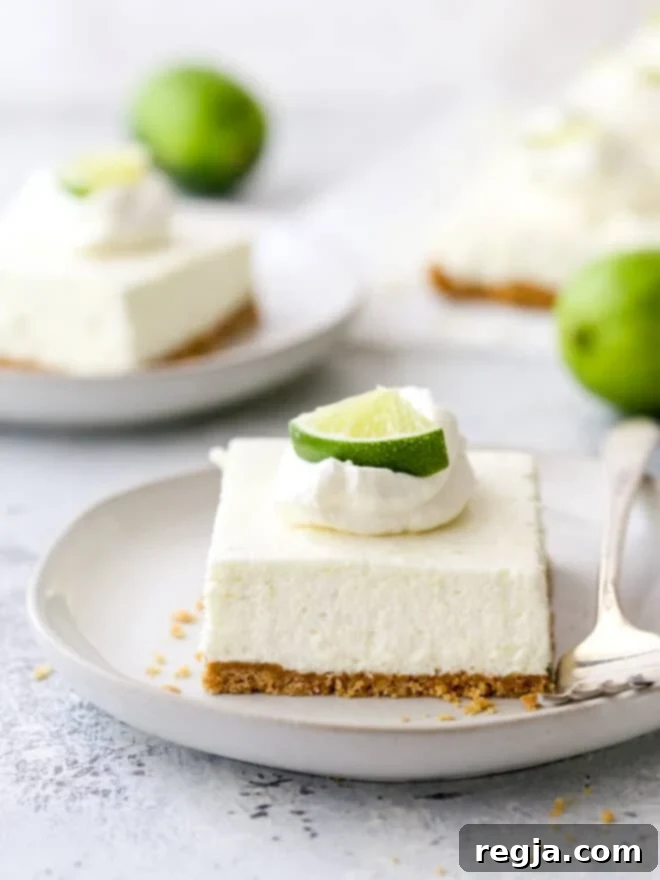 Μια φέτα μπάρες cheesecake λάιμ σε ένα πιάτο με ένα πιρούνι