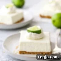 Μια φέτα μπάρες cheesecake λάιμ σε ένα πιάτο με ένα πιρούνι