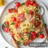 Λεμονάτη πάστα με ντομάτες και βασιλικό σε πιάτο με μαχαιροπίρουνα