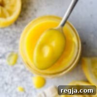 Πώς να φτιάξετε σπιτική λεμονοκρέμα 9 Ένα κουτάλι γεμάτο λεμονόκρεμα, με την κρεμώδη υφή και το έντονο κίτρινο χρώμα της, έτοιμη να απολαυστεί.