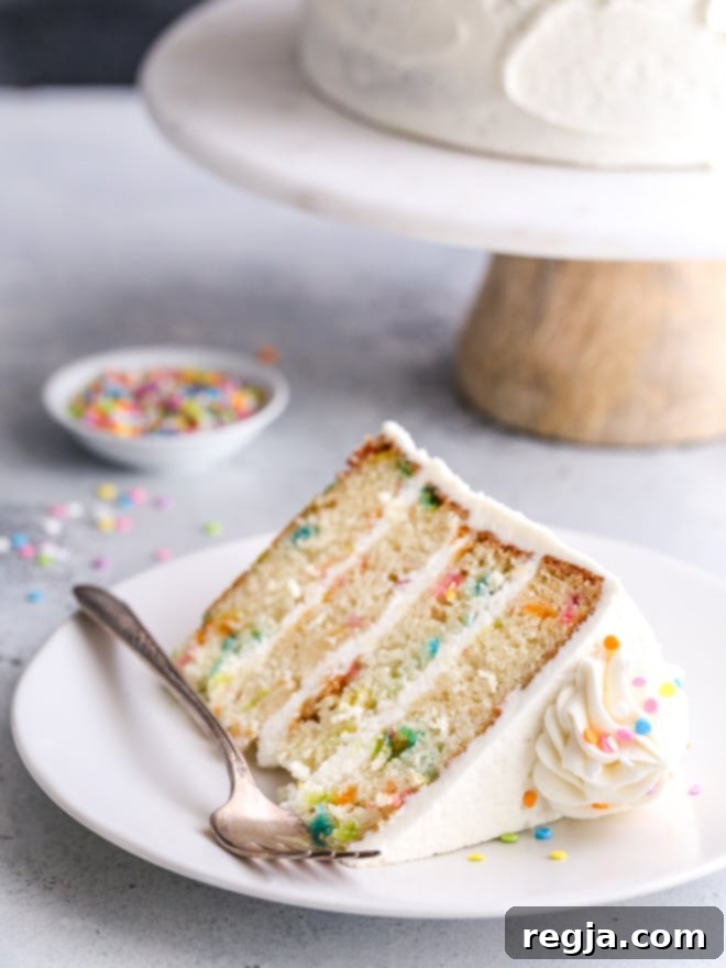 Αυτό το κέικ funfetti, φτιαγμένο με ανάλαφρες και βουτυράτες στρώσεις κέικ βανίλιας, γεμάτο με πολύχρωμα sprinkles και αφράτη βουτυρόκρεμα βανίλιας, είναι ένα διασκεδαστικό και χαρούμενο επιδόρπιο!